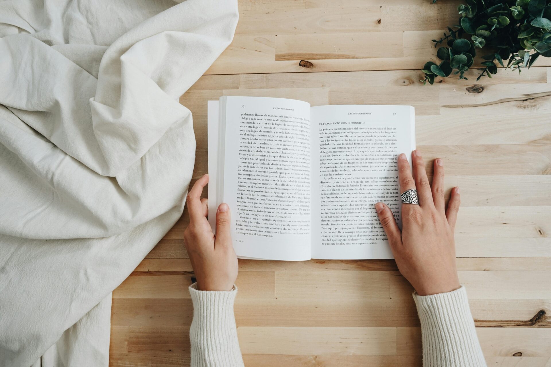 Manos sujetando un libro de superación personal abierto en 'Es de Leer