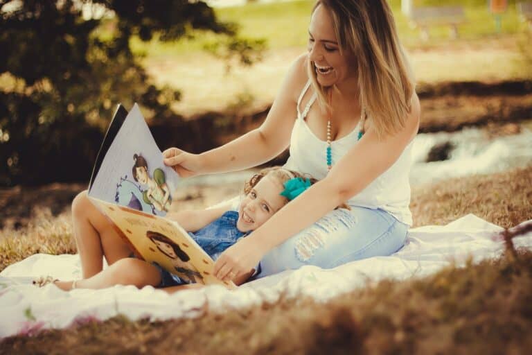 Mujer y niña leyendo juntas en un picnic al aire libre, capturadas por 'Es de Leer'."